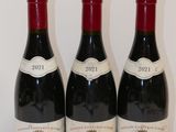 three bottles of red wine are lined up on a table
