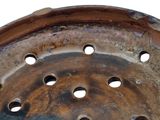 a rusted tire with holes in it on a white background