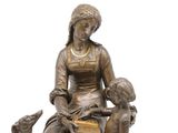 statue en bronze représentant une femme assise sur une chaise avec un chien