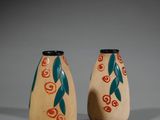 deux petits vases décorés, posés sur une table