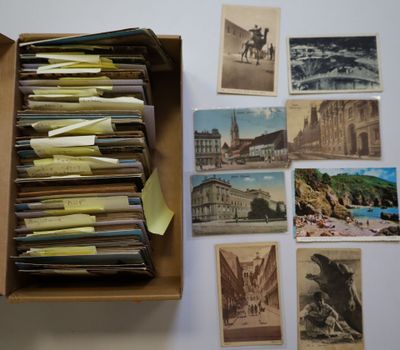 une boîte ouverte remplie d'une multitude de vieilles cartes postales, posée sur une table