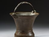 an old metal bucket with a handle sitting on top of a table