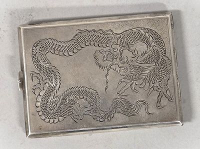 a silver box with a dragon on it on a table