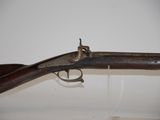 an old gun with a wooden handle on display in a museum