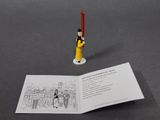 a small figurine of a man holding a red candle