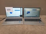 two laptops sitting side by side on a table