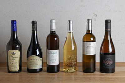 plusieurs bouteilles de vin sont alignées sur une table en bois