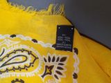 yellow scarf with black and white paisley design on it