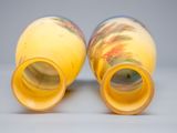 two yellow vases sitting next to each other on a table