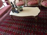 plusieurs chaises et une table dans une pièce recouverte d'un tapis rouge