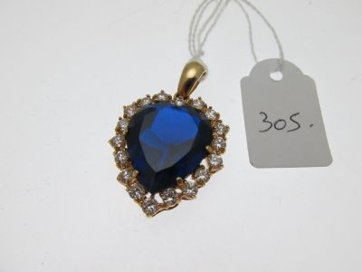 un gros plan d'un pendentif bleu en forme de cœur avec une étiquette de prix