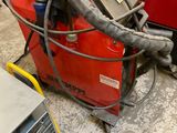 une machine posée à même le sol, à côté d'un tas de métal