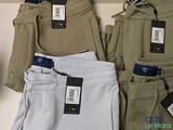 three pairs of men ' s pants sitting on a table with tags on them