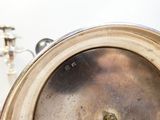 une horloge en argent posée sur une table à côté d'un candélabre en argent