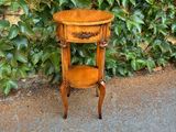 une petite table avec une étagère devant un mur recouvert de lierre