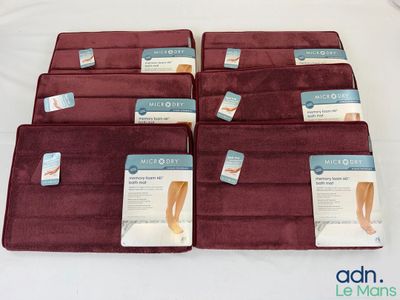 Six paires de semelles sont posées sur un lit recouvert d'un drap blanc.