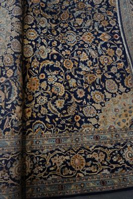 une photo d'un tapis bleu et or posé sur un parquet