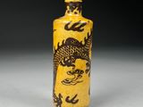 an image of a yellow and black vase with a dragon on it