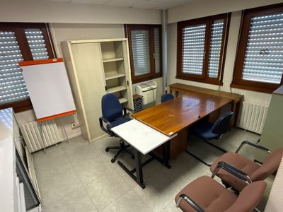 une pièce équipée d'une table, de chaises et d'un réfrigérateur