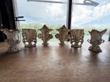 cinq vases posés sur une table devant une fenêtre