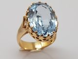 a close up of a gold ring with a blue topaz stone