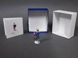 a small figurine of a man standing in front of a box