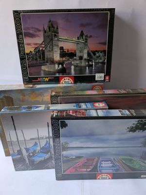 trois boîtes de puzzle sont empilées sur une table
