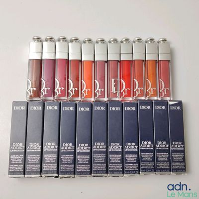 lip glosses are lined up in a row on a white surface