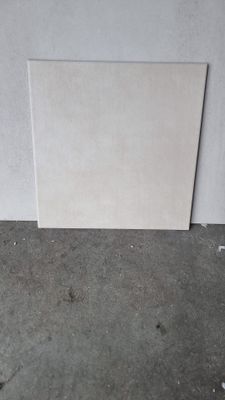 un morceau de papier blanc posé par terre près d'un mur