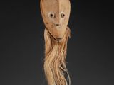 a wooden mask with long hair on a black base