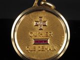 un gros plan d'une médaille d'or sertie d'un diamant