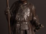 bronze statue of a man with a staff and a hat