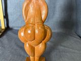 sculpture en bois représentant une femme tenant un bébé dans ses bras, posée sur un socle en bois