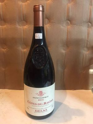 a bottle of wine sitting on a table next to a glass of wine