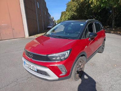 La voiture rouge est garée sur le bord de la route.
