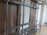 a long row of benches in a room with wooden walls