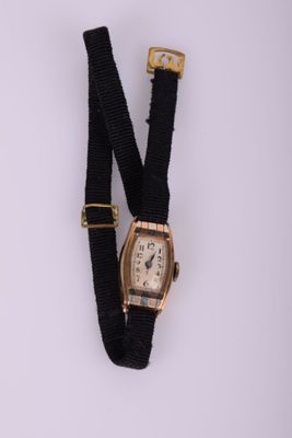 une photo d'une montre-bracelet avec un bracelet noir et une boucle dorée