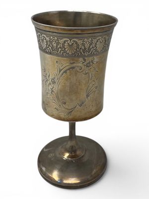 an antique silver cup with a floral design on the rim