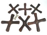 four crosses are placed on a white surface with a screw in the middle of them