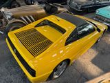 a yellow car parked in a lot with other cars