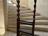 une chaise en bois posée devant un escalier