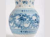 a blue and white vase with a floral design on it