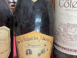 three bottles of wine sitting on a table with a red cloth