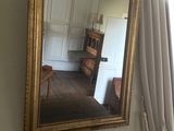a mirror hanging on the wall next to a dresser