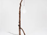 a wooden floor lamp with a light bulb on top of it