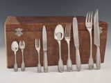 une boîte en bois sur laquelle est posé un service d'argenterie