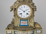 une horloge posée sur une table, sur laquelle se trouve un oiseau