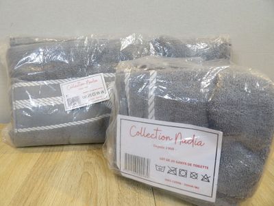 two bags of gray towels sitting on top of a wooden table