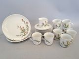 un grand nombre de tasses et de soucoupes sur une table