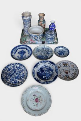 many blue and white plates and vases on the table